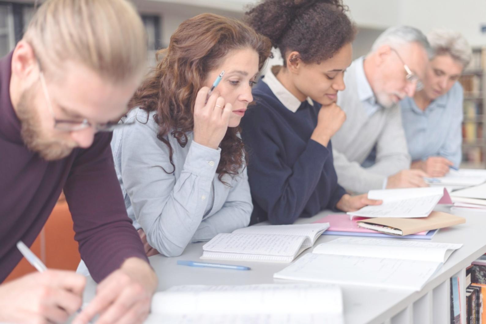 Étudiant analysant des données économiques sur plusieurs écrans